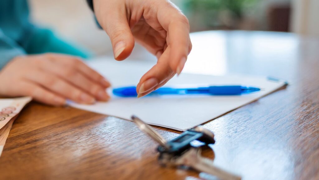 Un hombre está firmando un documento, en esta nota de los principales cambios que trae la ley de remuneraciones